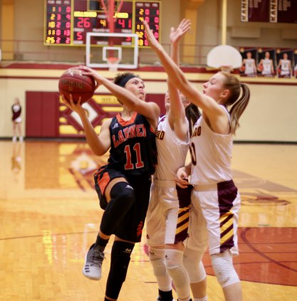 Katelynn Sanger scores over two Trojan defenders..jpeg