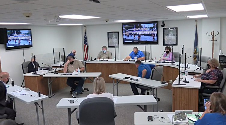 city council meeting with shields and masks