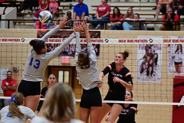 Cassie Ellegood spikes over Andover's volleyball players.jpg