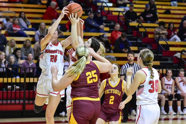 Hoisington's Kylee Hahn and Lexus Petersilie jump over Victoria's defenders to gat a rebound.jpg