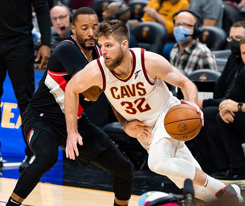 Dean Wade driving to the basket for the Cavaliers, highlighting his aggressive playing style